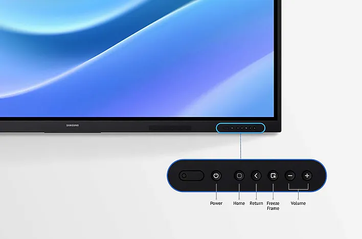 Samsung monitor with a rounded control panel below the screen showing power, home, return, freeze frame, and volume controls (plus/minus).