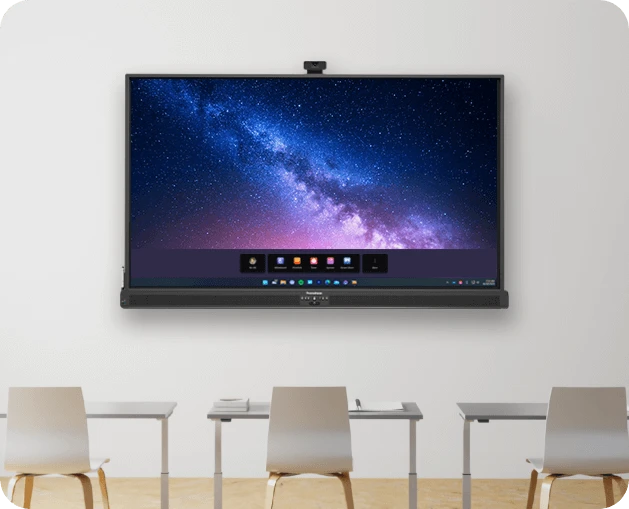 Wall-mounted large screen displaying a starry sky image with a video conferencing toolbar, in front of four empty white desks and chairs in a bright meeting room.