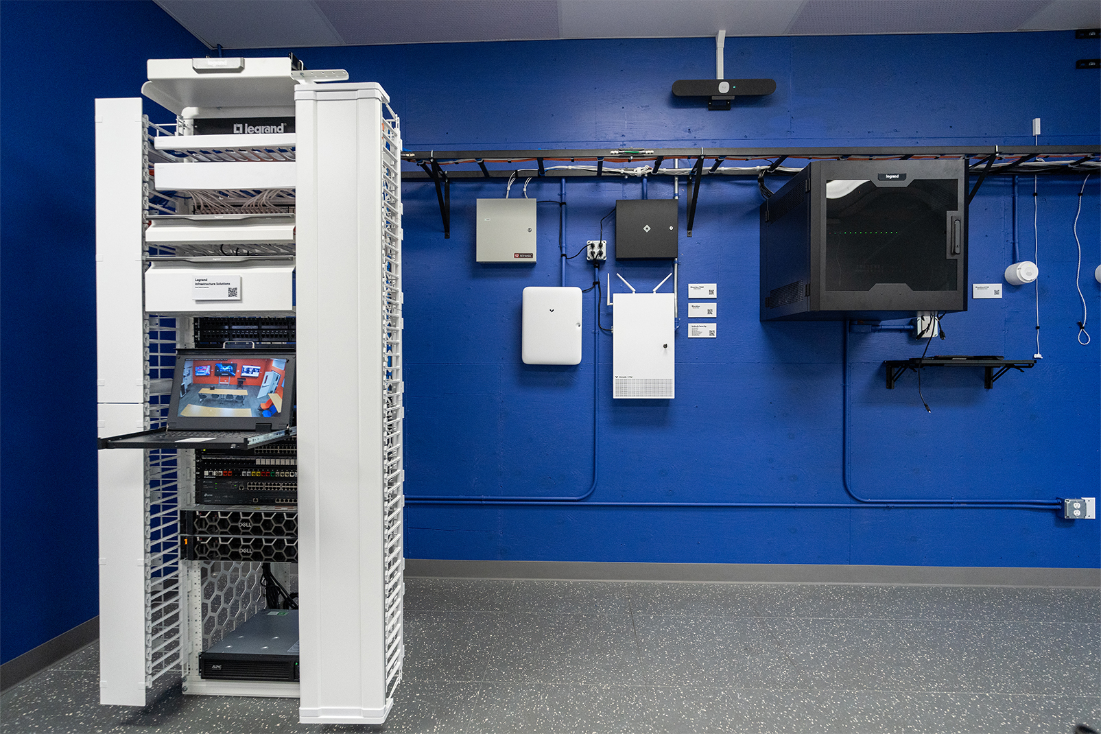 Tall white server rack with networking gear inside a blue-walled data room